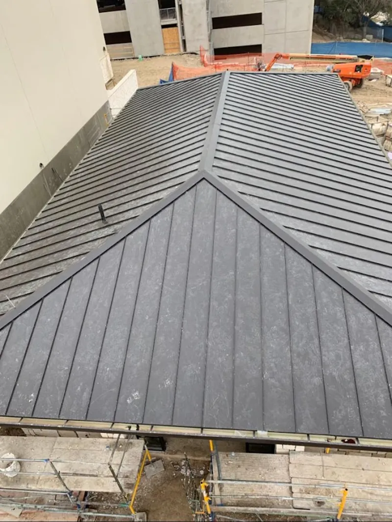 Commercial metal roof construction with crane equipment in Sheridan